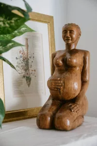 a wooden statue of a pregnant woman
